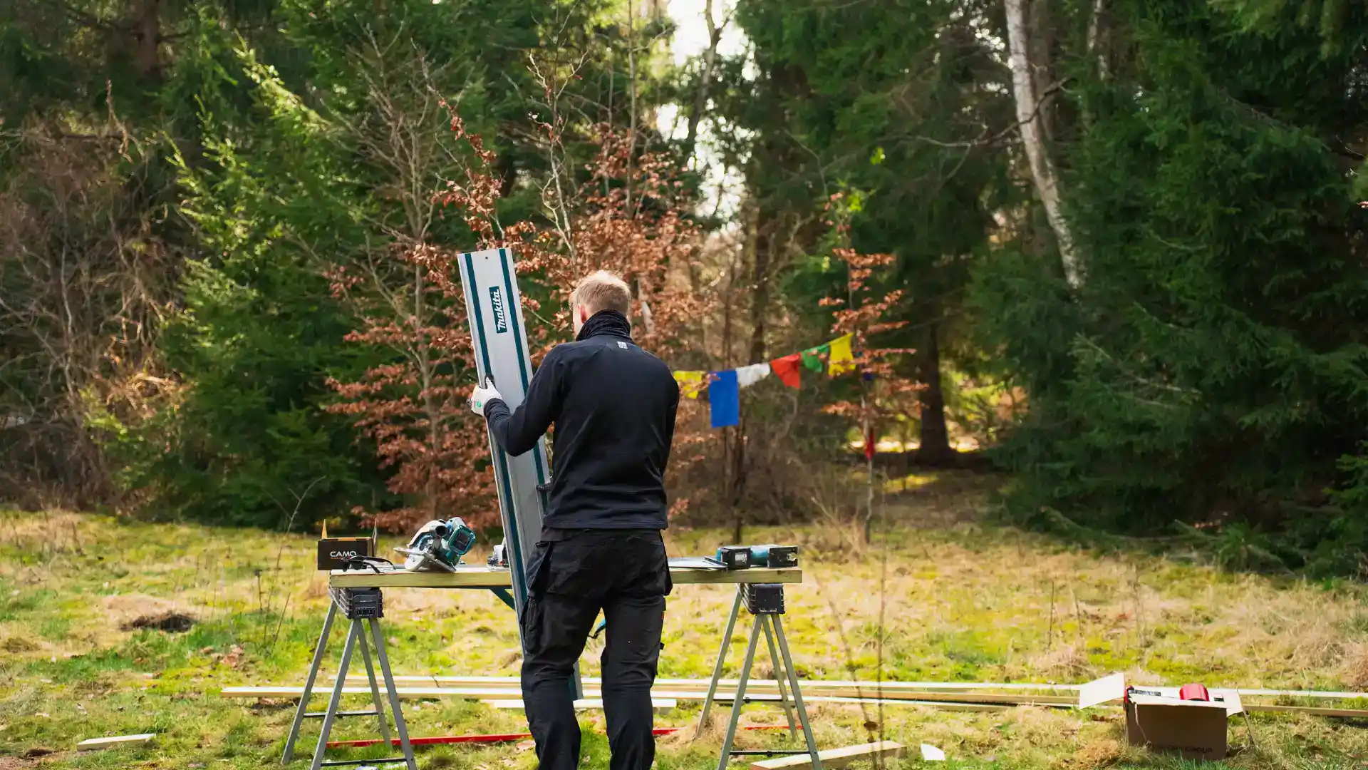 Mandsarbejde med træ, der skæres og forberedes i skov.