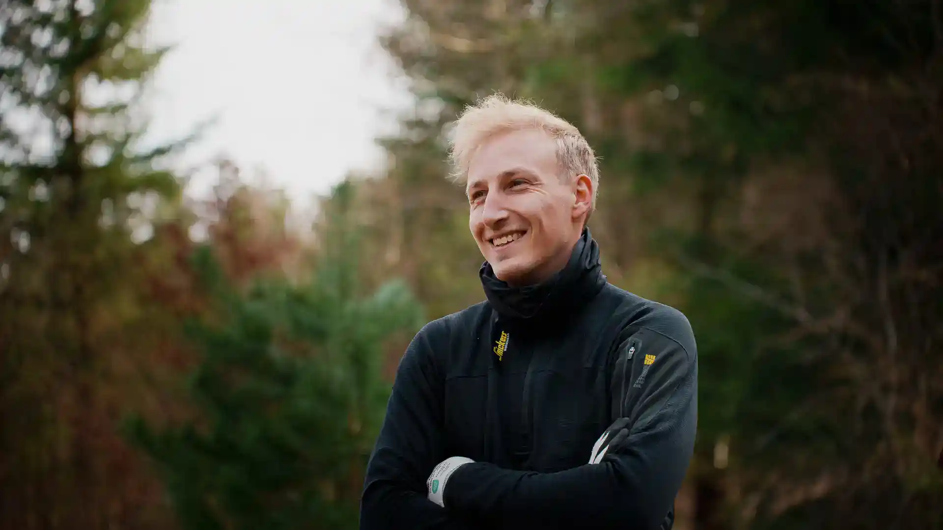 Smilende mand i udendørs træarbejde, professionel træentreprenør i naturen.