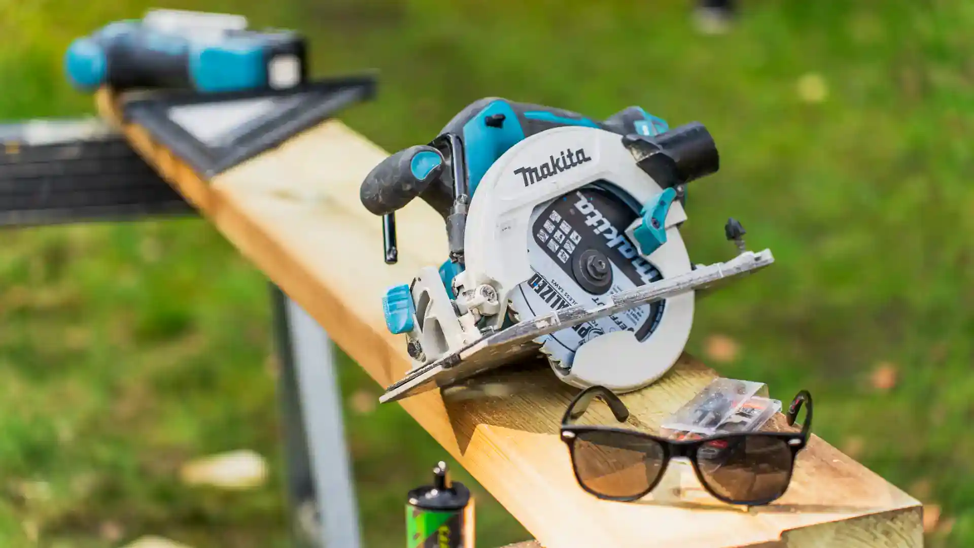 Bærbar rundsave og værktøj til træbearbejdning på arbejdsbord.